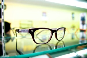 Glasses resting on a glass shelf.